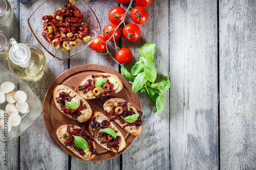 Appetizer bruschetta with sun-dried tomatoes, olives and mozarel