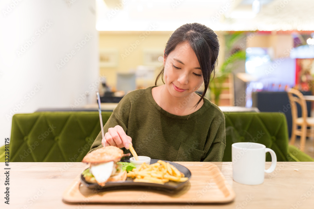 Woman having French fries in restaurant