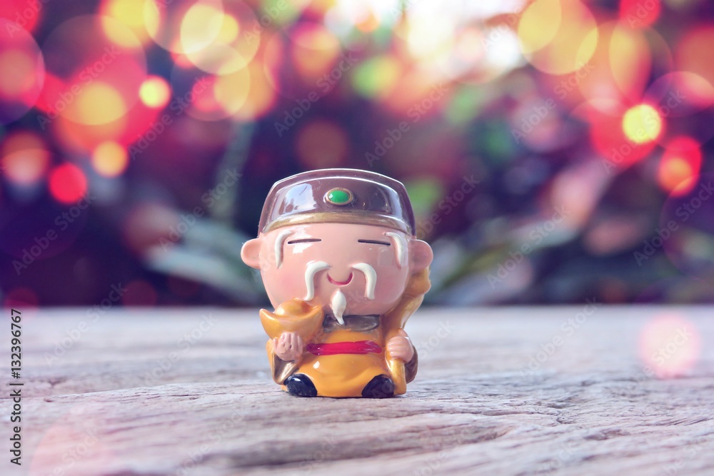Little cute chinese monk on wooden table abstract background. Small cute sculpture monk blur background
