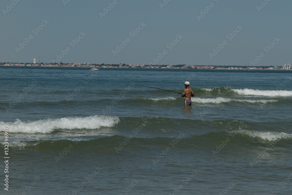 A retired fisherman in the water on the beach A retired fisherman in the water on the beach