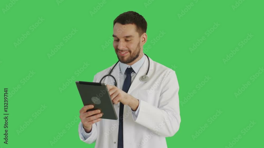 Mid Shot of a Smiling Handsome Doctor Makes Swiping Gestures on a Tablet Computer. Background is Green Screen. Shot on RED Cinema Camera 4K (UHD). Mid Shot of a Smiling Handsome Doctor Makes Swiping Gestures on a Tablet Computer. Background is Green Screen. Shot on RED Cinema Camera 4K (UHD).