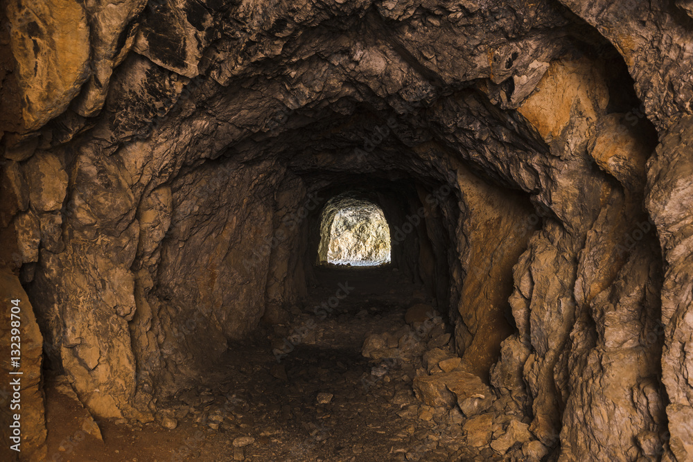 Obraz premium Interno di una cava buia con l'uscita illumina in vista in fondo