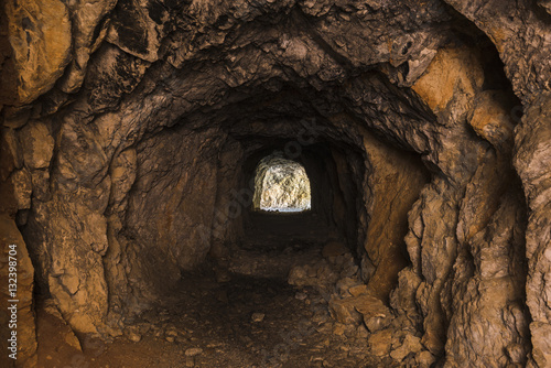 Interno di una cava buia con l'uscita illumina in vista in fondo