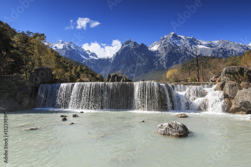 Waterfall on foreground and Jade Dragon Snow Mountain on background - Yunnan  China