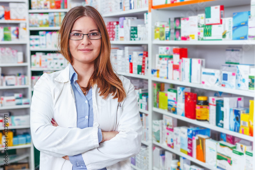 Cheerful pharmacist chemist woman standing in pharmacy drugstore