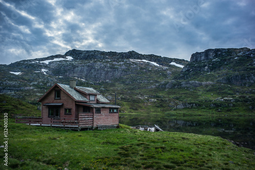 Old house in Norwegian lake and dramatic sky