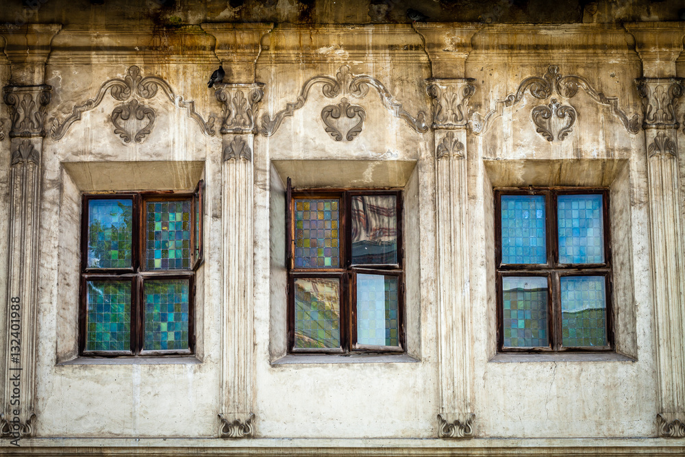 Color picture of old dirty three windows facade