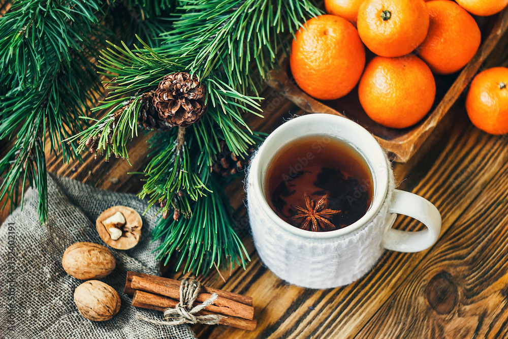 Christmas New Year composition winter holiday celebration concept symbol tangerines clementine nuts pine cones fir branches cup tea rustic style old wooden board selective focus festive greeting card