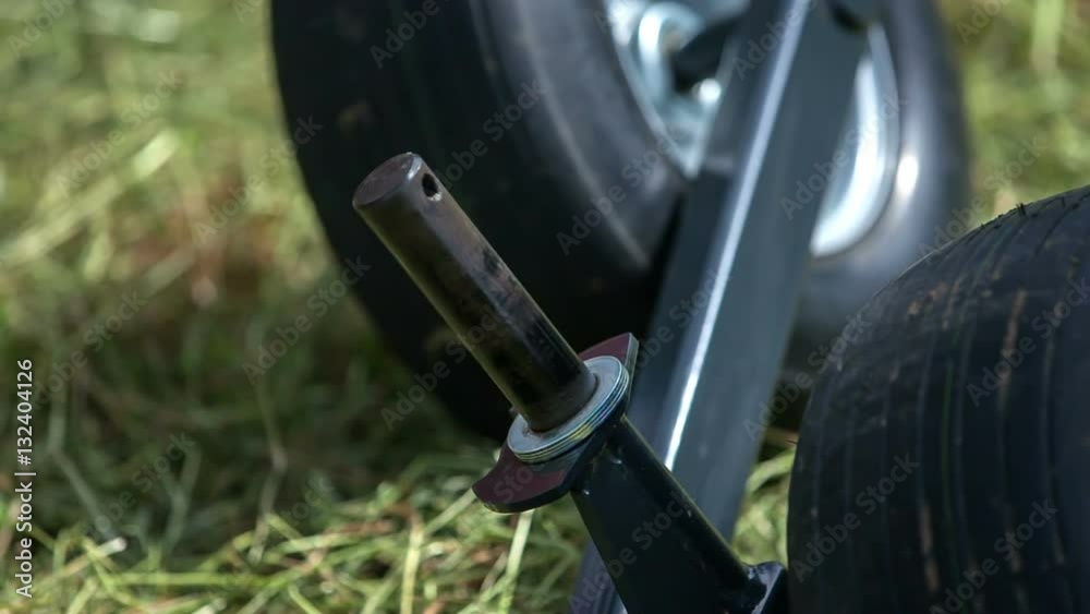A young man is putting one small item back on its place and he is fixing the rotary hay rakes.
A young man is putting one small item back on its place and he is fixing the rotary hay rakes.