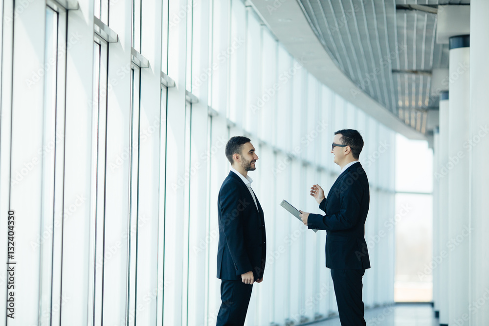 Two businessmen having informal meeting in modern office