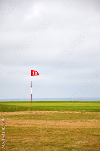 flag on golf course and sea 