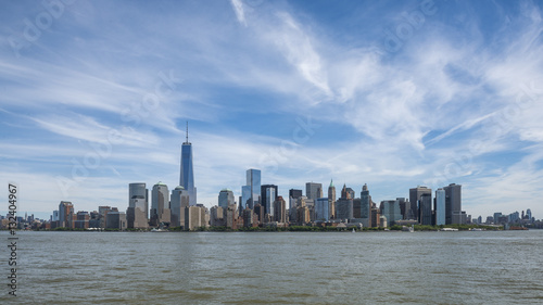 Vista dello skyline di Manhattan, NewYork da sud con il One Trade Center sulla sinistra e un cielo blu con qualche nuvola. © Tomas