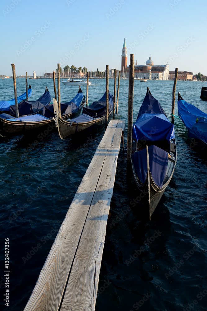 Gondolas at wooden pier in Venice in Italy
