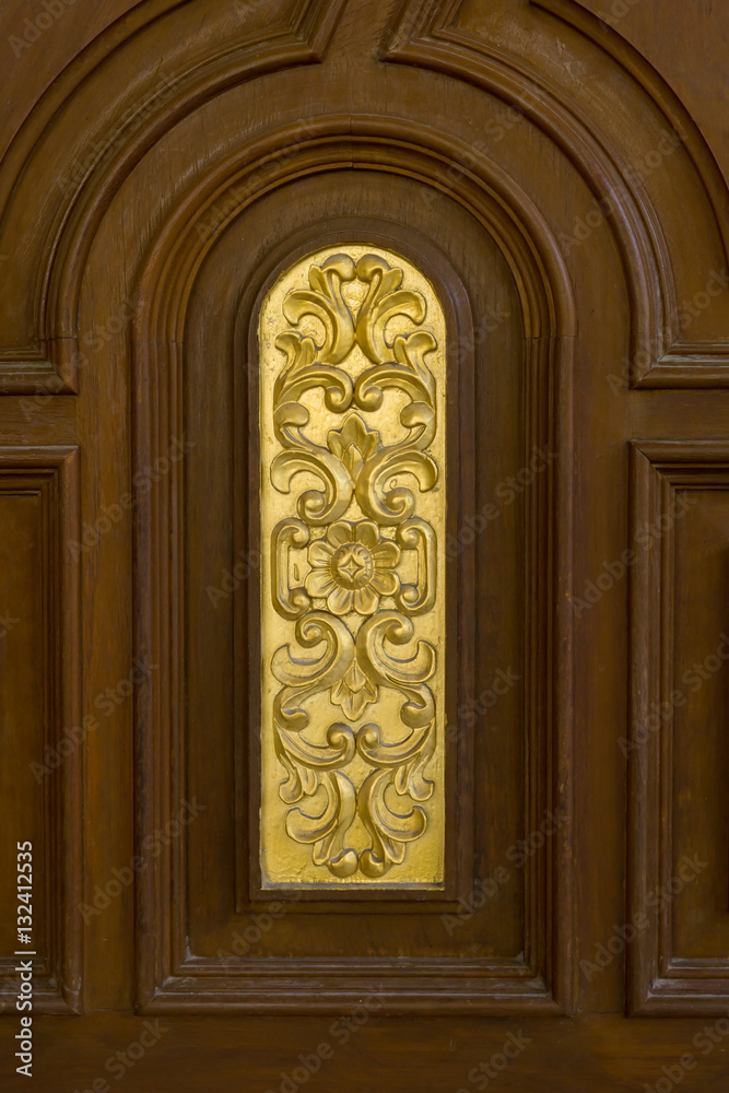 teak wood door with gold carving.
