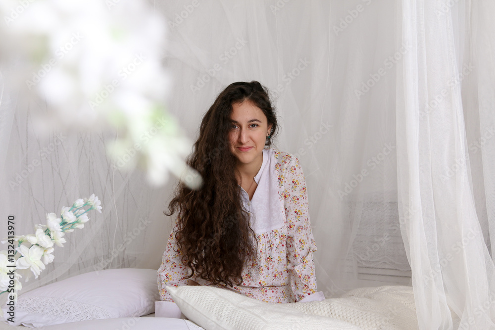 young girl sitting on a white bed in dress Stock Photo | Adobe Stock