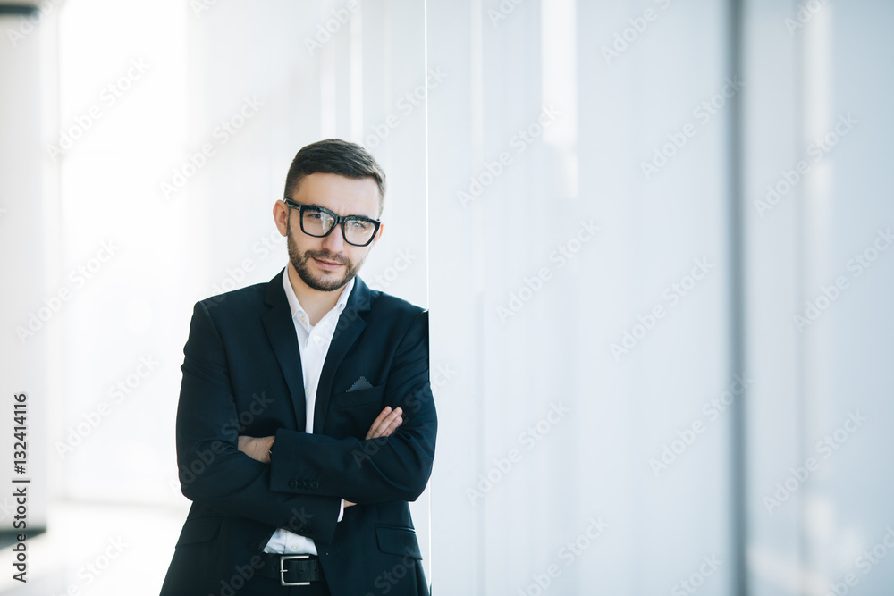 Handsome businessman in suit and eyeglasses on windows background Handsome businessman in suit and eyeglasses on windows background
