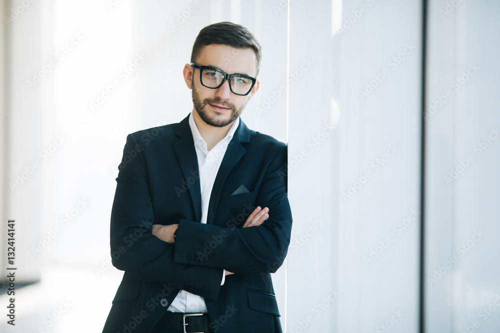 Handsome businessman in suit and eyeglasses on windows background Handsome businessman in suit and eyeglasses on windows background