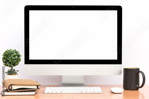 Office monitor computer, mouse on wooden table and white wall background