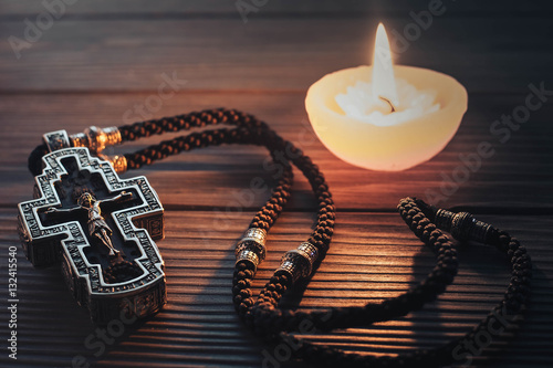 Silver orthodox cross on a wooden texture