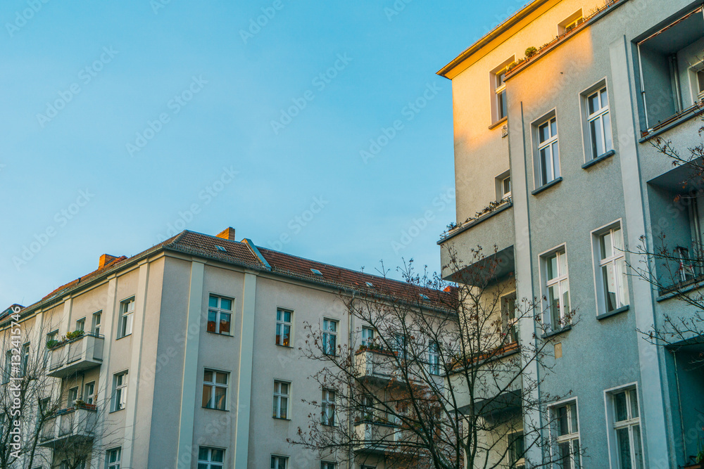 Naklejka premium apartment houses in a street with clear blue sky