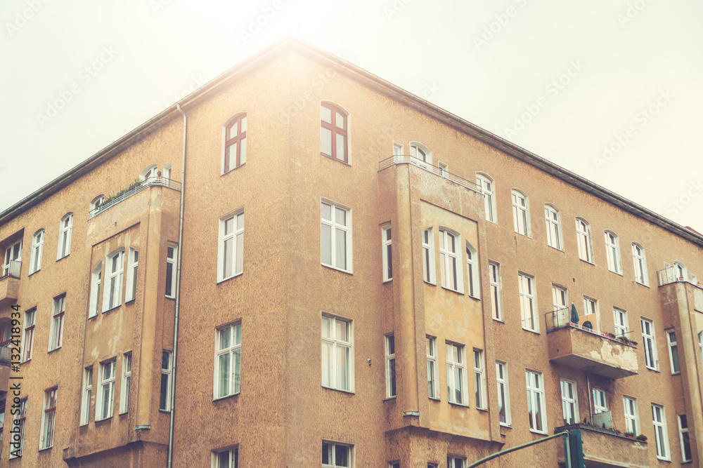 Fototapeta premium old corner house in sunlight with ddr facade