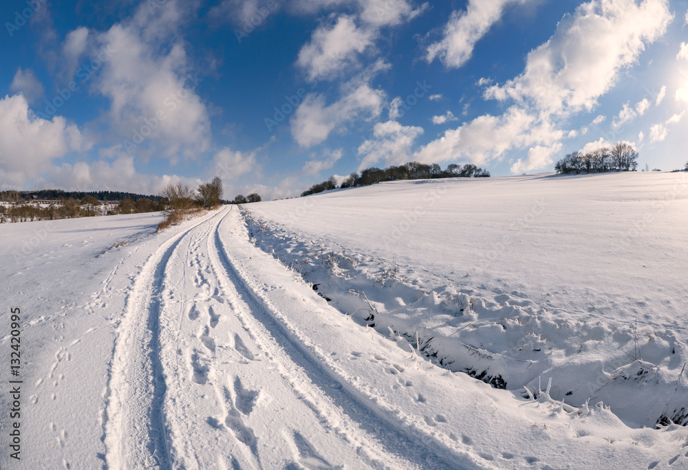 Wanderwege in verschneiter Landschaft mit blauem Himmel