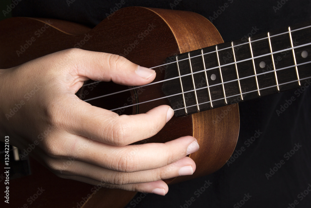 Fototapeta premium Somebody playing ukulele in close up view.