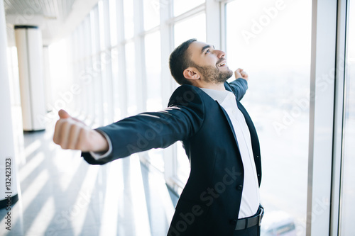 excited young caucasian businessman celebrate victory cheerful in modern office photo