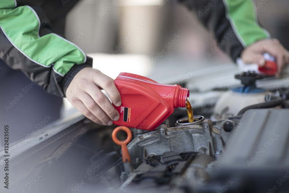 Man filling up car with motor oil Man filling up car with motor oil