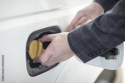 Man closing petrol cap of car at fuel station