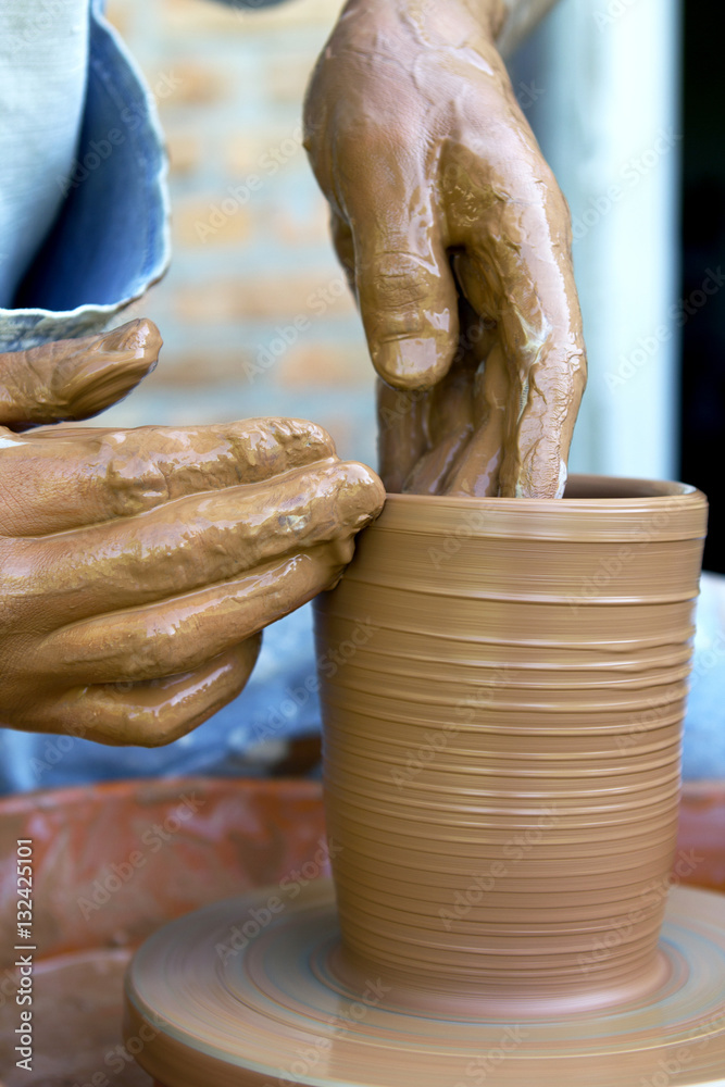 potter makes a jug out of clay