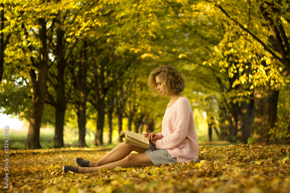 woman is reading book in the autumn park woman is reading book in the autumn park