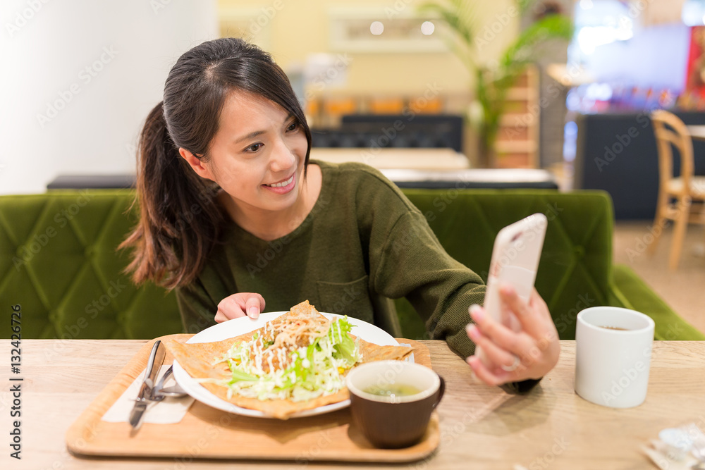 Woman taking selfie by cellphone in restaurant Woman taking selfie by cellphone in restaurant