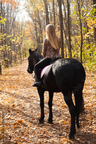 girl walking in the autumn forest on horseback © izida1991