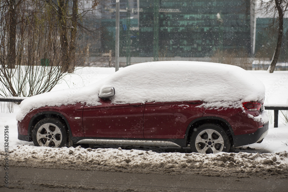 Car covered with fresh white snow. A vehicle under the snow