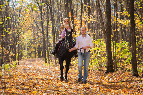 young family walking in the autumn forest with a horse © izida1991