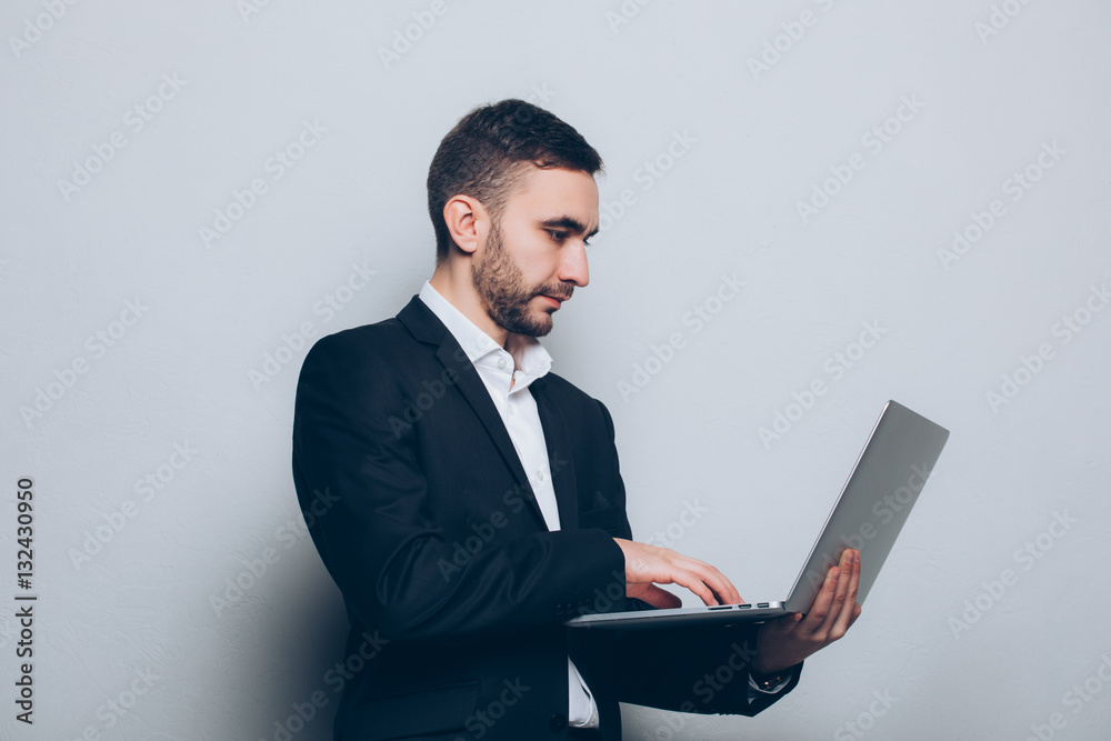 Young businessman in suit with laptop in hands isolated Young businessman in suit with laptop in hands isolated