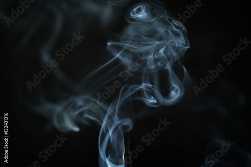 mystery blue smoke over dark background closeup, shallow focus