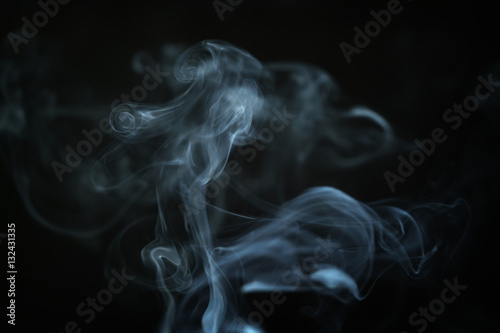 mystery blue smoke over dark background closeup, shallow focus