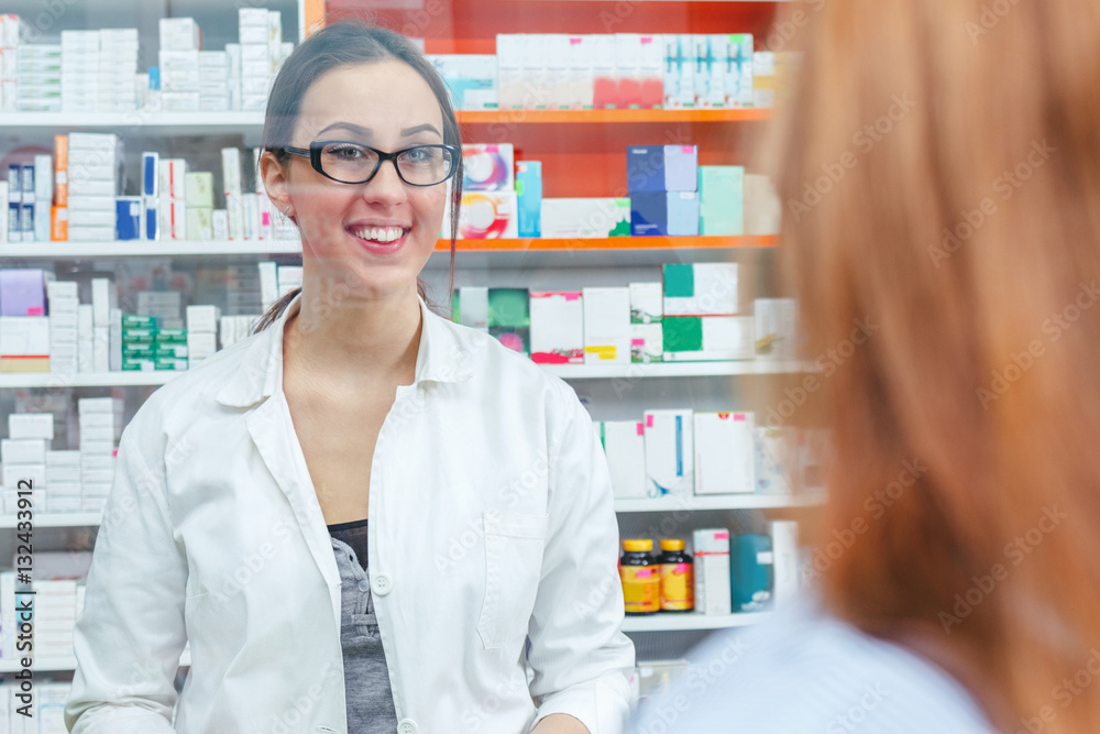 Pharmacist talking with a customer at the pharmacy desk
