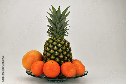 Tropical fruit on a platter  pineapple  mandarin and grapefruit.