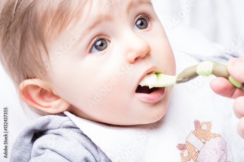 Valokuva infant girl fed by her mother's hand