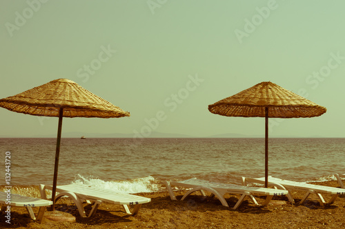 Fototapeta Naklejka Na Ścianę i Meble -  Straw umbrellas on empty seaside beach in Turkey