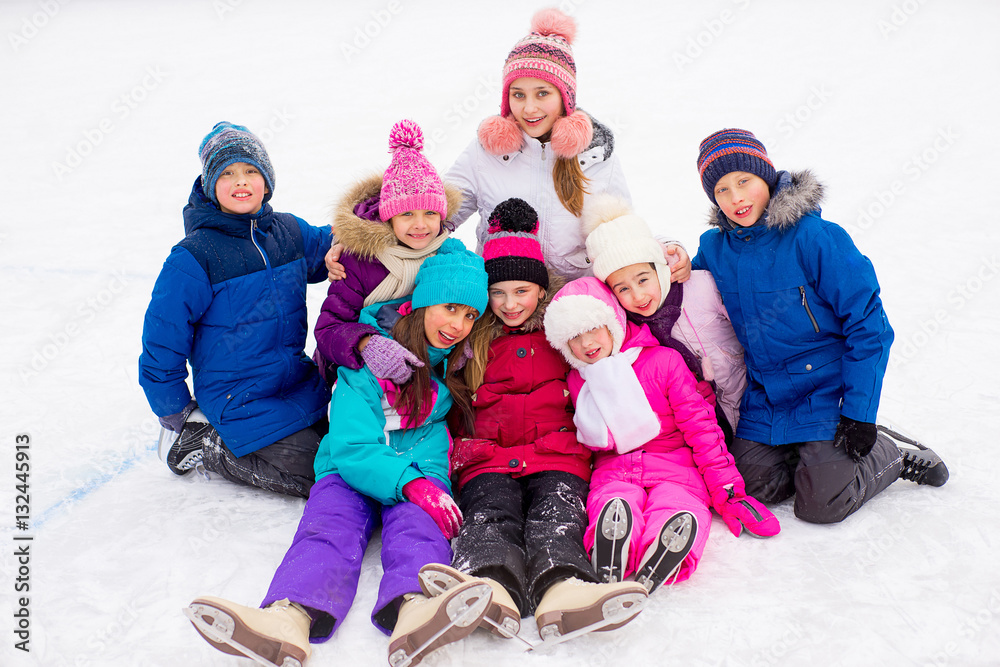 group of kids sitting on the ice
