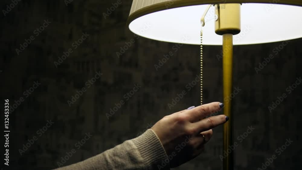 woman's hand turn off the lamp