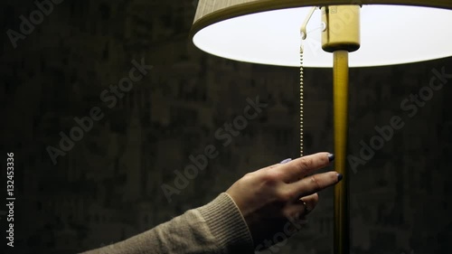 woman's hand turn off the lamp
