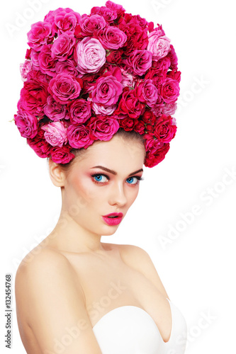 Young beautiful woman with stylish make-up in fancy vintage style wig of pink roses over white background, copy space