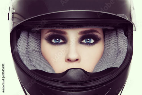 Vintage style close-up portrait of young beautiful woman with stylish make-up in biker helmet © Olga Ekaterincheva