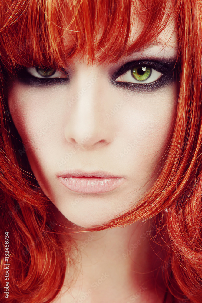Vintage style close-up portrait of young beautiful red-haired green-eyed girl with smoky eyes make-up