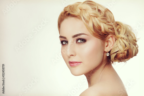 Vintage style portrait of young beautiful blond woman with fancy prom hairdo and smoky eyes make-up